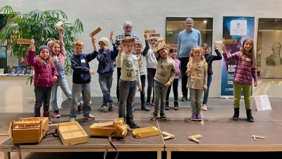 Stolz präsentieren die Mädchen und Buben ihre selbst gebastelten Karfreitagsratschen. (Foto: Museum Erding)