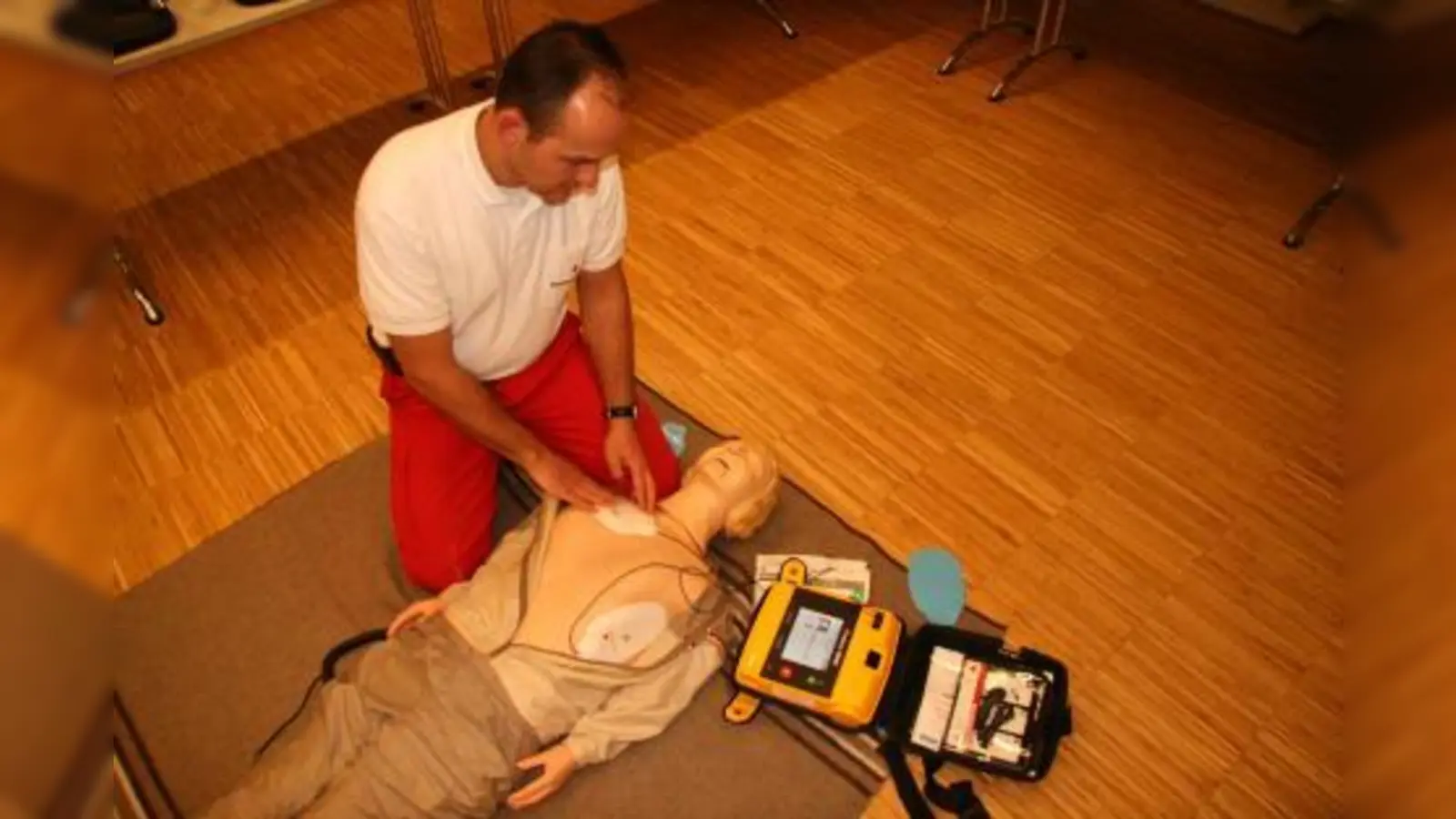 „Das Gerät sagt jedem Helfer, was genau zu tun ist. Im Prinzip sind es drei Schritte, die man befolgen muss.“ Roman Dreesbach vom BRK Krailling-Planegg bei der Demonstration eines Defibrillators. (Foto: US)