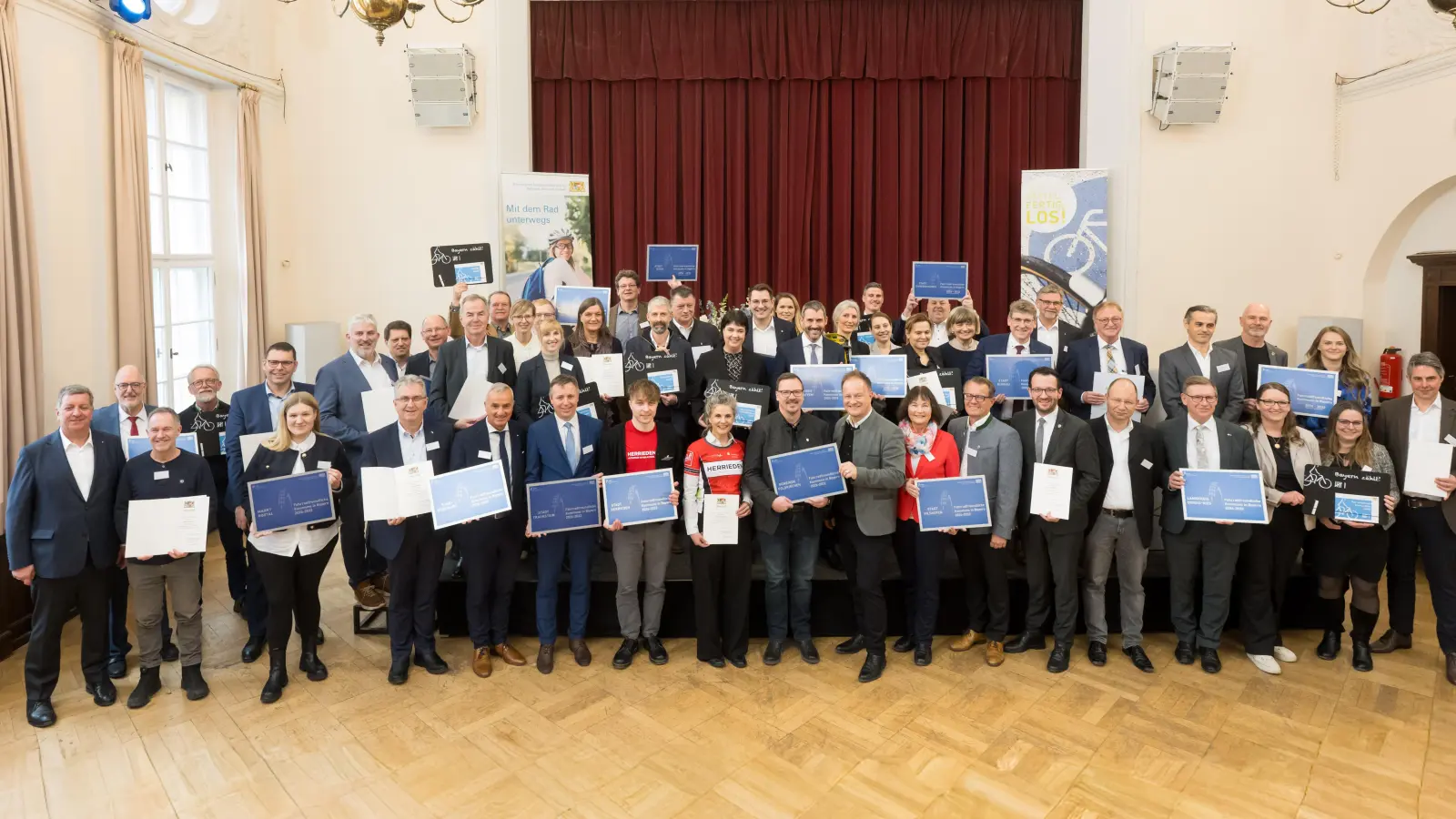 Die Delegationen der zertifizierten und re-zertifizierten Mitgliedskommunen mit dem Staatsminister für Wohnen, Bau und Verkehr, Christian Bernreiter, und dem Vorsitzenden der AGFK, Robert Niedergesäß. Mit dabei war auch Feldkirchens Bürgermeister Andreas Janson (1. Reihe, 9. von links). (Foto: AGFK Bayern/Tobias Hase)