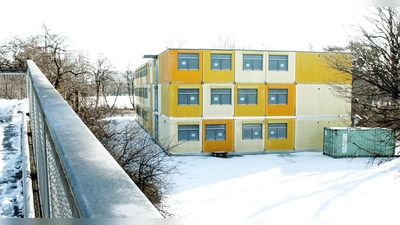 Auf dem Grundstück, auf dem derzeit die Container stehen, soll das Pflegeheim gebaut werden. Links der Haderner Steg, der die Autobahn quert. (Foto: job)