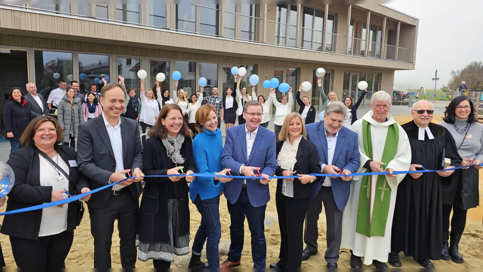 Das Band durchtrennen (v.l.) Andrea Sailer, Jan und Angela Spreen, Kerstin Schempp, Manfred Walter, Steffi Weller, Heinrich Lenker, die Pfarrer Franz von Lüninck und Rainer Hess, Miriam Haas. (Foto: Gemeinde Gilching)