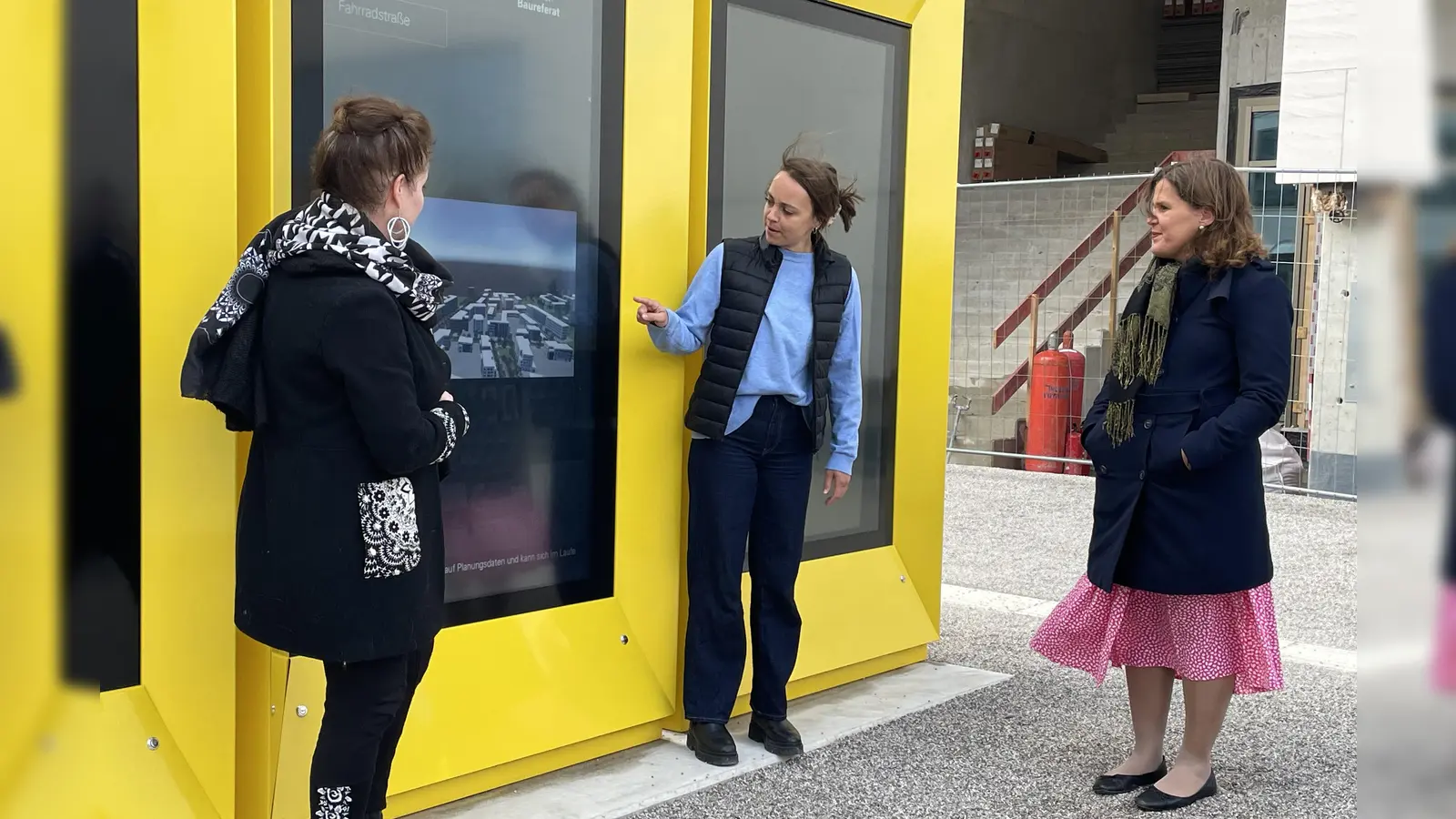 Mit dem Finger auf den Bildschirm tippen: Luisa Zsolnay vom Baureferat zeigt Baureferentin Jeanne-Marie Ehbauer (l.) und Bürgermeisterin Verena Dietl (r.), wie die Infostele funktioniert. (Foto: Patrizia Steipe)