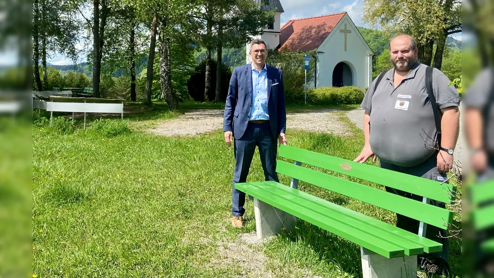Bürgermeister Frank Zellner (links) und Bauhofleiter Hermann Deutschenbauer präsentieren die neue Sitzbank an der Knappenkapelle. (Foto: Markt Peißenberg)