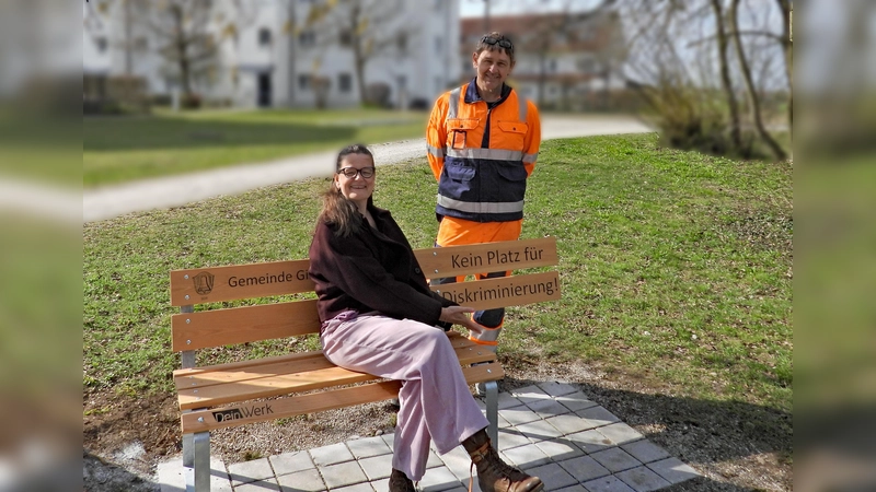 Sabine Ayhan (Inklusionsbeauftragte) und Bauhofmitarbeiter Jürgen Grübler bei einer der neuen Bänke gegen Diskriminierung. (Foto: Gemeinde Gilching)
