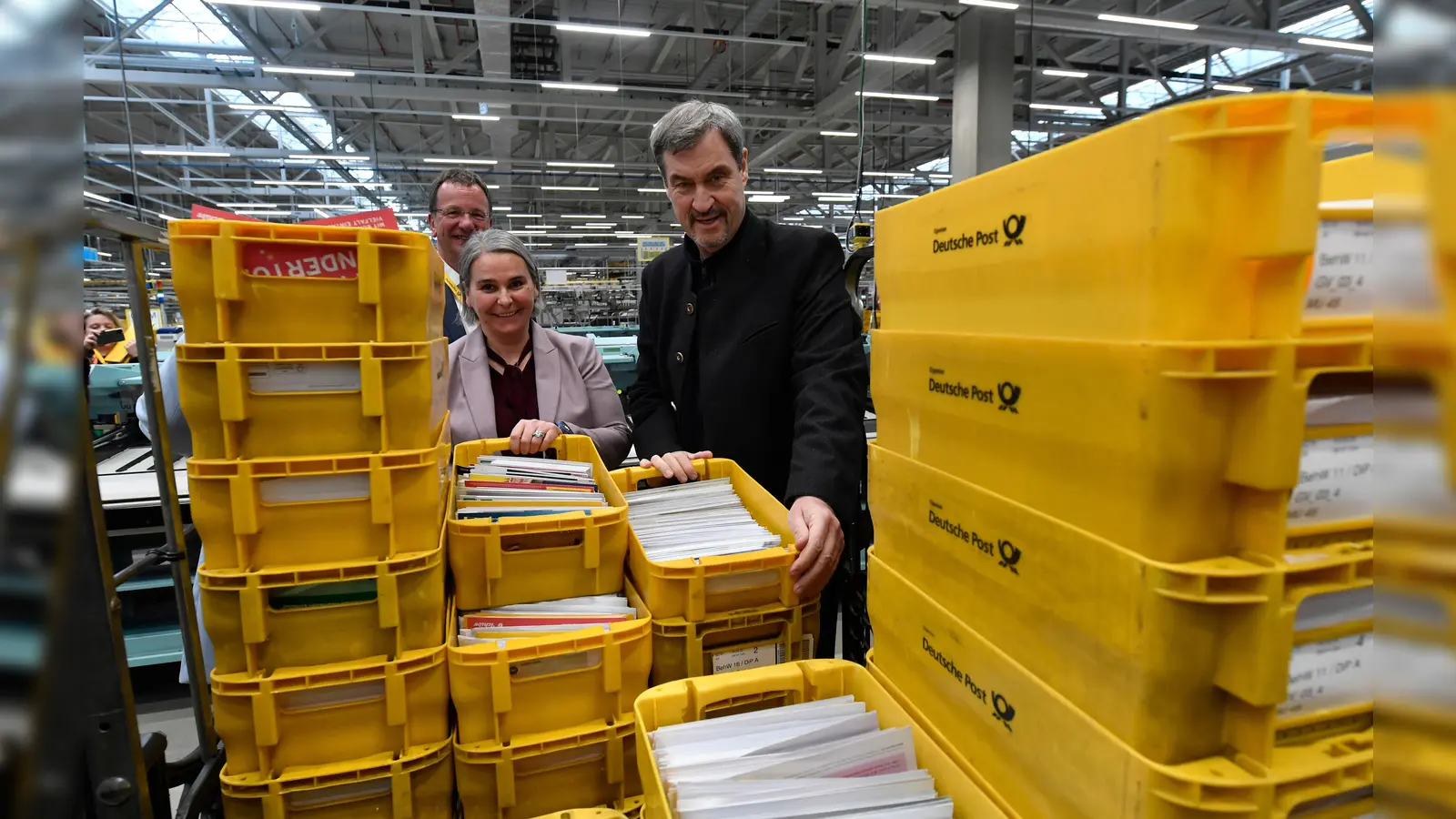 Ministerpräsident Markus Söder vor den vollen Postboxen mit Nikola Hagleitner (DHL-Konzernvorständin) und OB Andreas Haas (l.) (Foto: DHL Group)