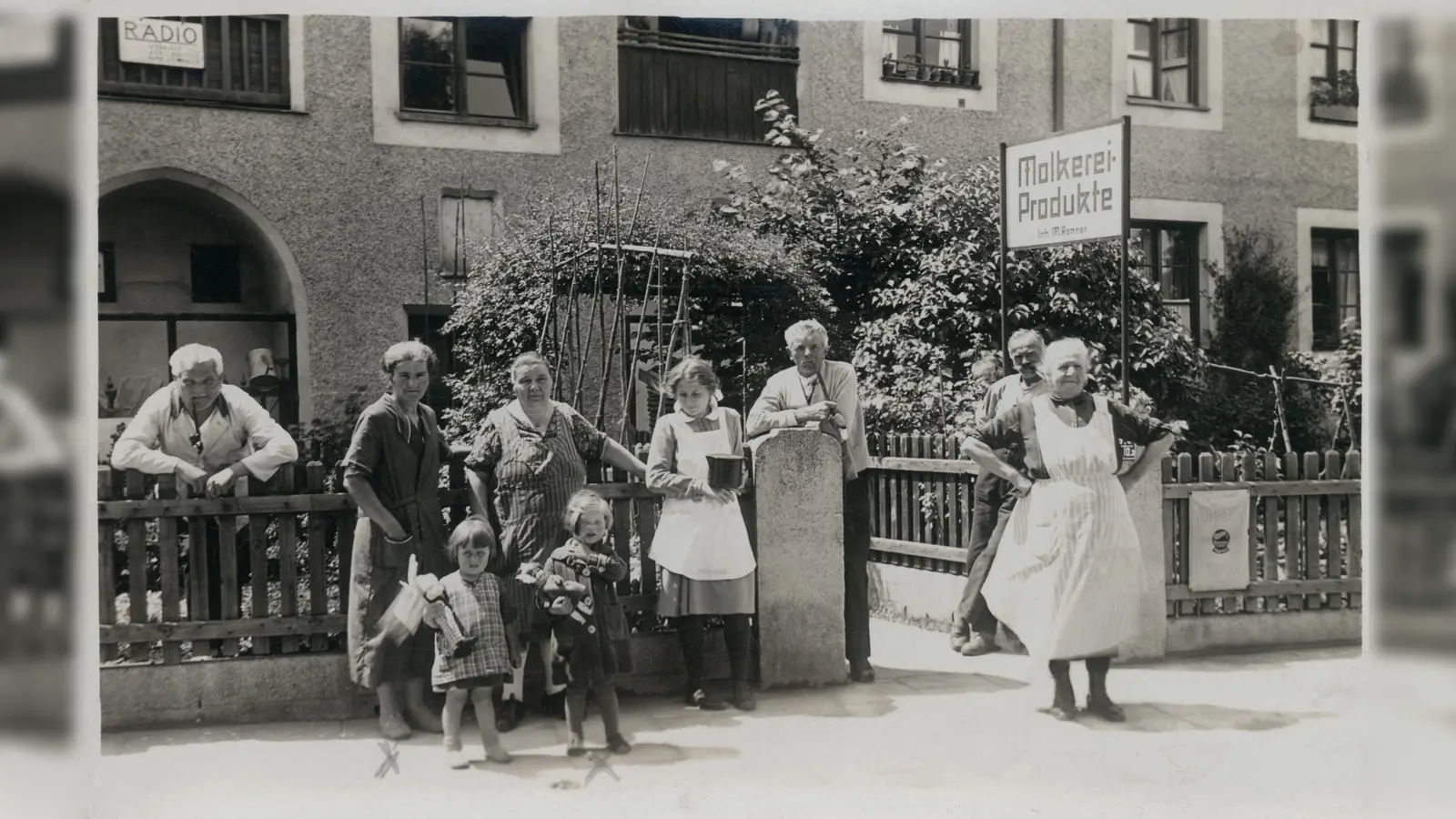 Für die Menschen in einer Stadt ist es wichtig, dass sie die Dinge des alltäglichen Bedarfs in ihrer Nähe finden. Geschäfte und Betriebe, Händler und Dienstleister vor Ort machen die Viertel und Nachbarschaften zu lebendigen Quartieren und tragen die Gemeinschaft. Fehlen sie, wird es für alle schwierig. Das war schon vor 100 Jahren so, als diese Aufnahme am Gartenzaun der Aidenbachstraße 6 entstand: Hier konnten die Münchner damals Molkerei-Produkte erstehen, wie das Schild am Eingang verrät. Mit den Münchner Wochenanzeigern können die Einzelhändler und Dienstleister nach wie vor alle Haushalte über ihre Angebote und Produkte informieren. (Foto: Stadtarchiv München DE-1992-FS-PK-STB-14185)