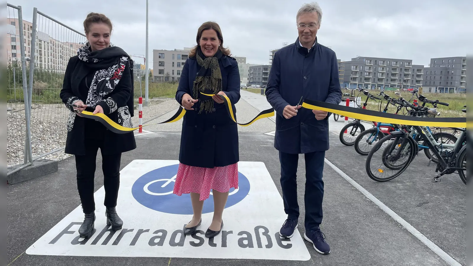 Baureferentin Jeanne-Marie Ehbauer, Bürgermeisterin Verena Dietl und Mobilitätsreferent Georg Dunkel durchtrennen das Band zur offiziellen Eröffnung der Fahrradstraße. (Foto: pst)