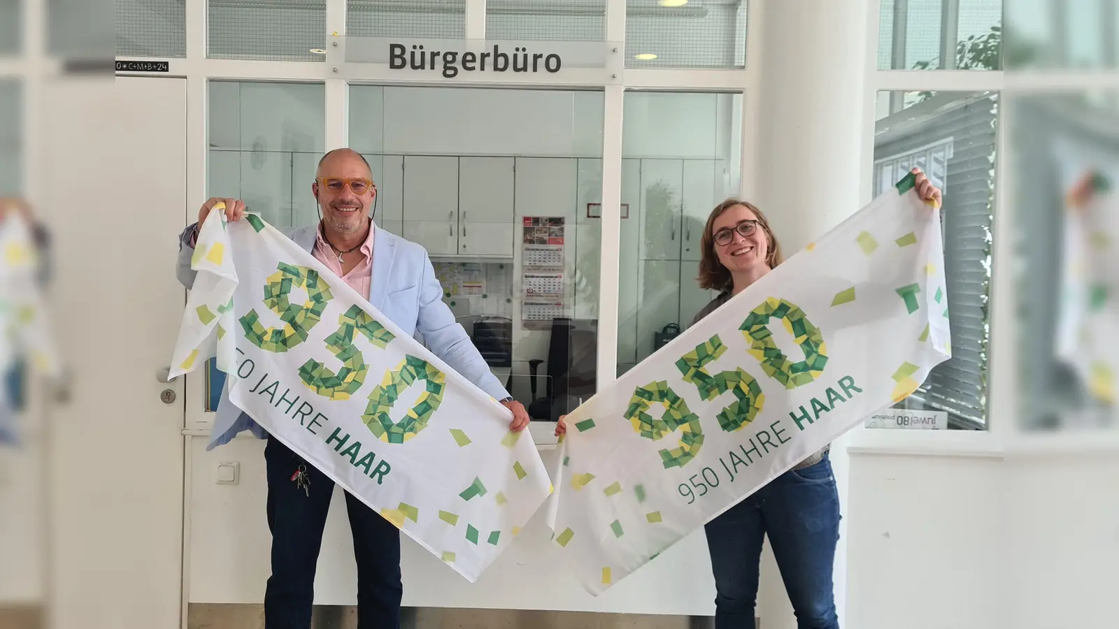 Christian Trisl und Klimaschutzmanagerin Hannah Link wollen die Fahnen und Banner von der Haarer 950-Jahr-Feier zu Einkaufstaschen verarbeiten. (Foto: Gemeinde Haar)
